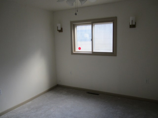 empty room featuring carpet flooring and ceiling fan