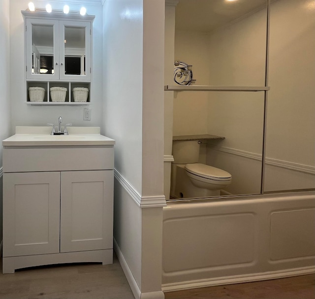 full bathroom featuring shower / bath combination with glass door, wood-type flooring, vanity, and toilet