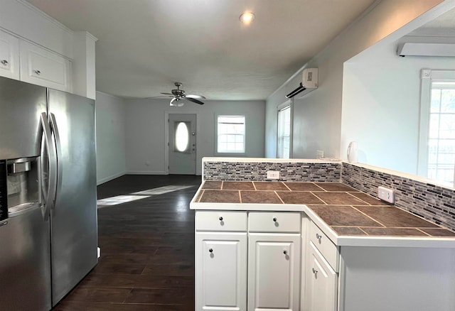 kitchen featuring stainless steel fridge, dark hardwood / wood-style flooring, backsplash, ceiling fan, and white cabinetry