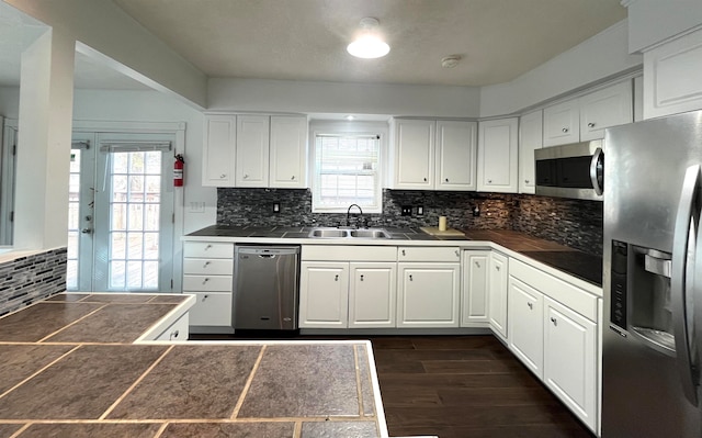 kitchen with sink, white cabinetry, stainless steel appliances, and a wealth of natural light