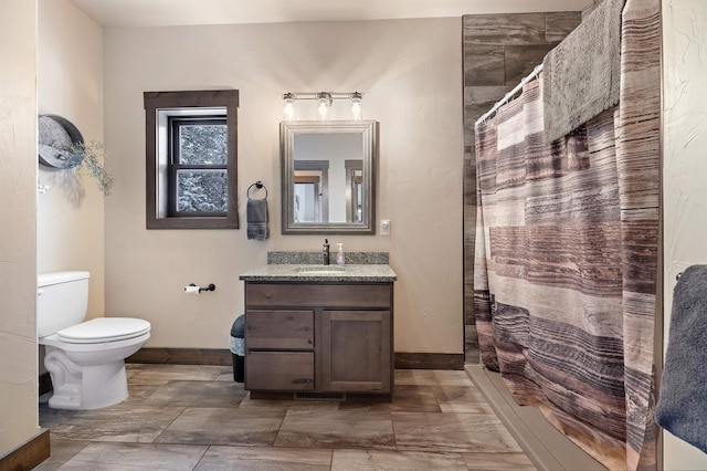 bathroom featuring vanity, toilet, and curtained shower