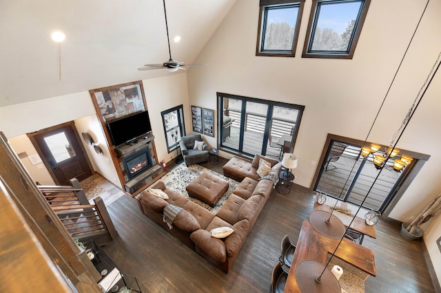 living room featuring ceiling fan with notable chandelier, dark hardwood / wood-style flooring, and high vaulted ceiling