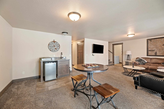 living room featuring a textured ceiling, light colored carpet, and sink