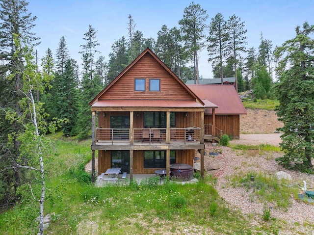 back of property featuring a hot tub