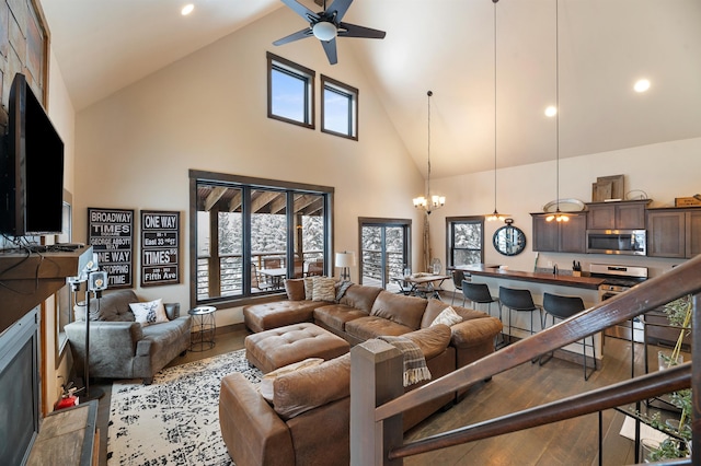 living room featuring ceiling fan with notable chandelier, light wood-type flooring, and high vaulted ceiling