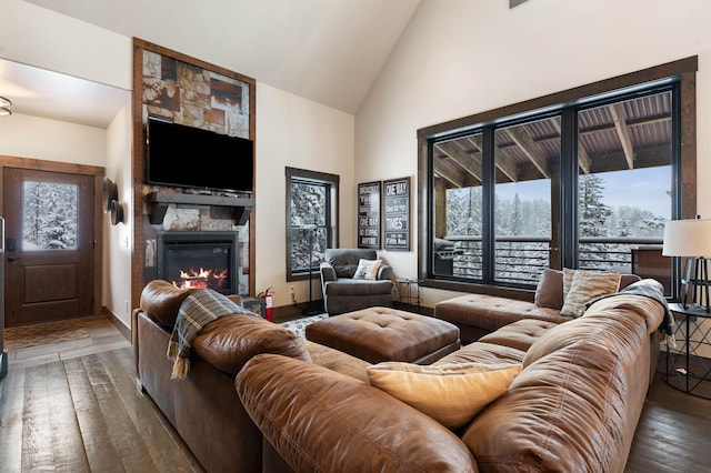 living room featuring a fireplace, wood-type flooring, and high vaulted ceiling