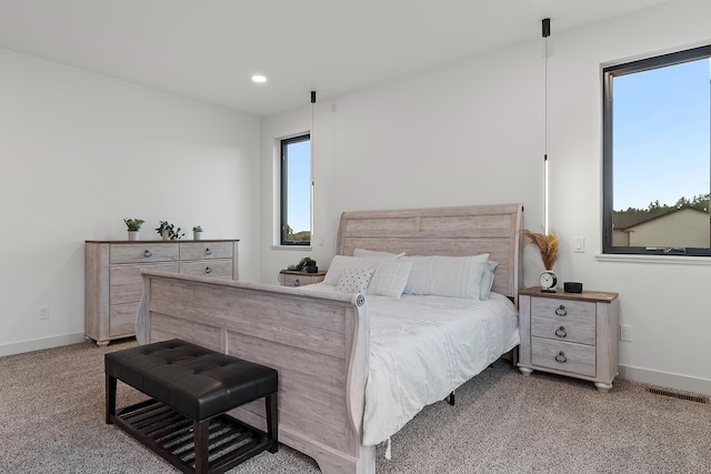 bedroom with light carpet and multiple windows