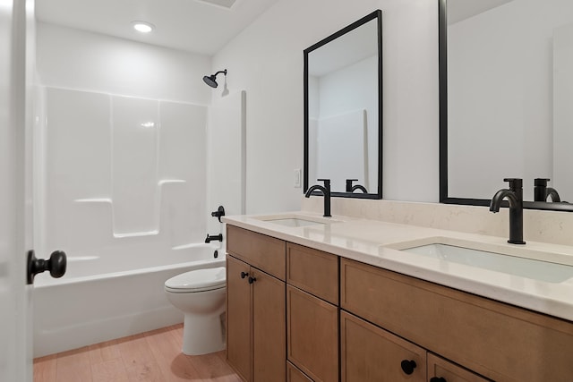 full bathroom with toilet, vanity, wood-type flooring, and tub / shower combination