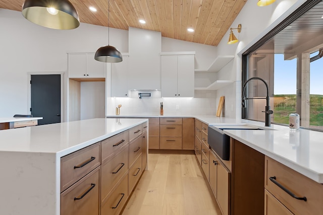 kitchen featuring white cabinetry, wooden ceiling, light hardwood / wood-style floors, pendant lighting, and vaulted ceiling