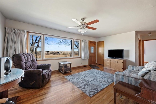 living room with light hardwood / wood-style flooring and ceiling fan