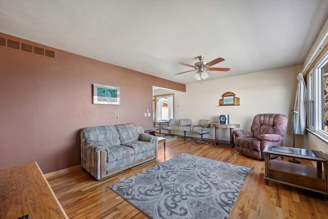 living room featuring ceiling fan and light hardwood / wood-style floors