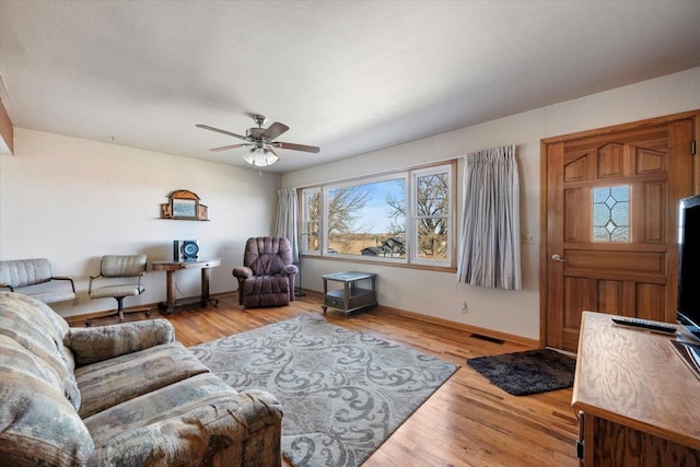 living room with ceiling fan and light hardwood / wood-style flooring