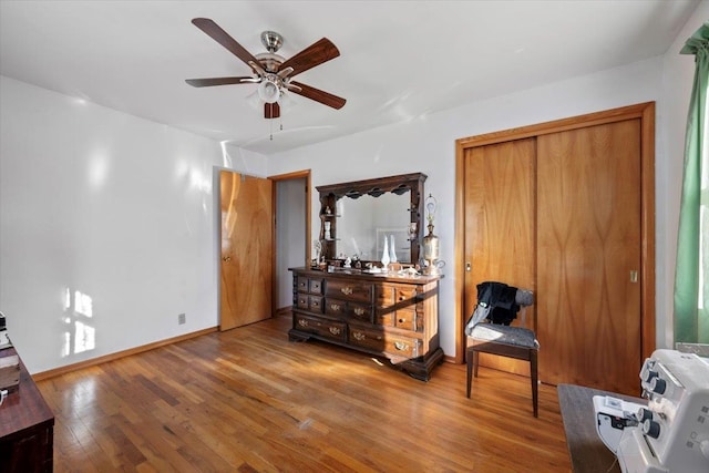 living area with hardwood / wood-style floors and ceiling fan