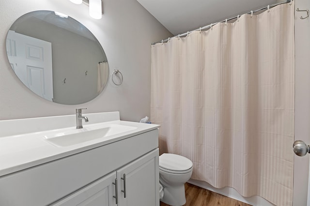 bathroom featuring curtained shower, toilet, vanity, and hardwood / wood-style flooring