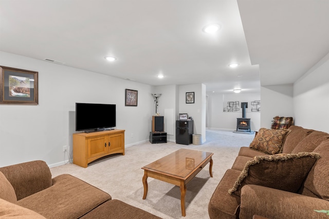 carpeted living room with a wood stove