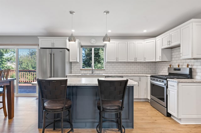 kitchen with a wealth of natural light, white cabinetry, and appliances with stainless steel finishes