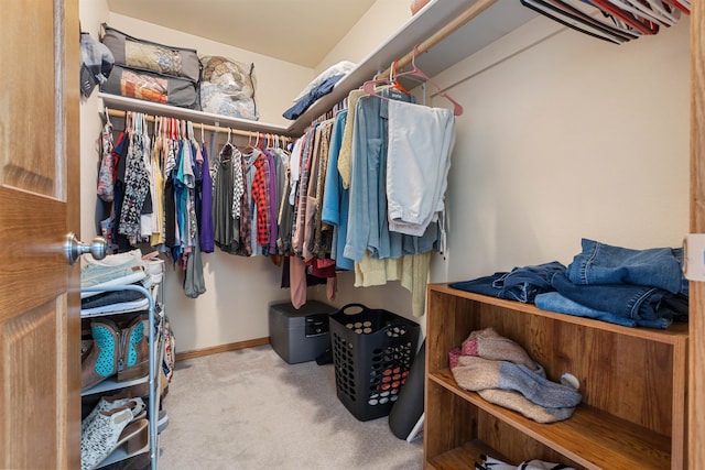 walk in closet featuring light carpet