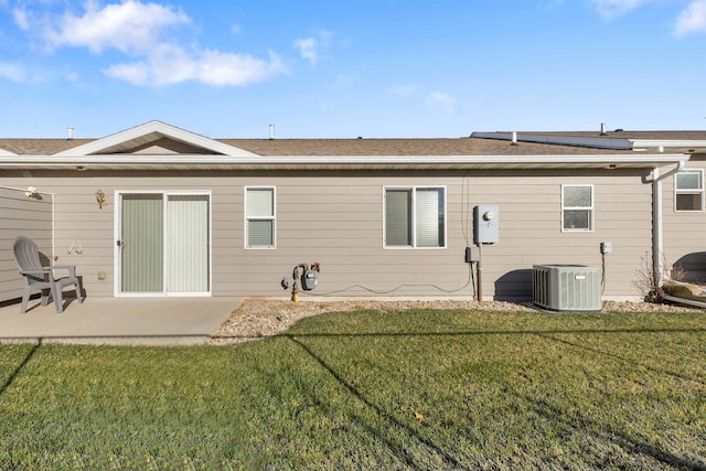 rear view of house with a yard, a patio, solar panels, and central air condition unit