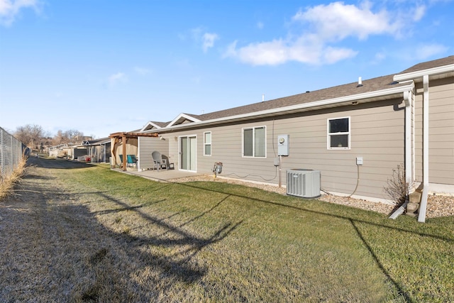 rear view of house with central air condition unit, a lawn, and a patio