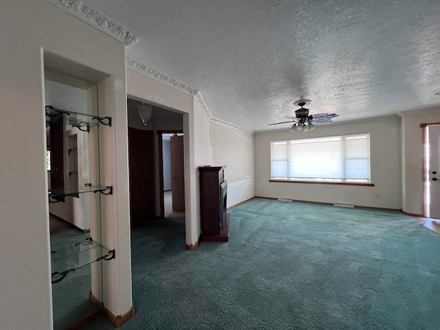 unfurnished living room featuring ceiling fan, crown molding, carpet, and a textured ceiling