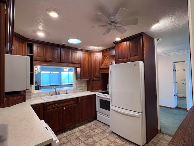 kitchen featuring custom exhaust hood, a textured ceiling, white appliances, ceiling fan, and sink