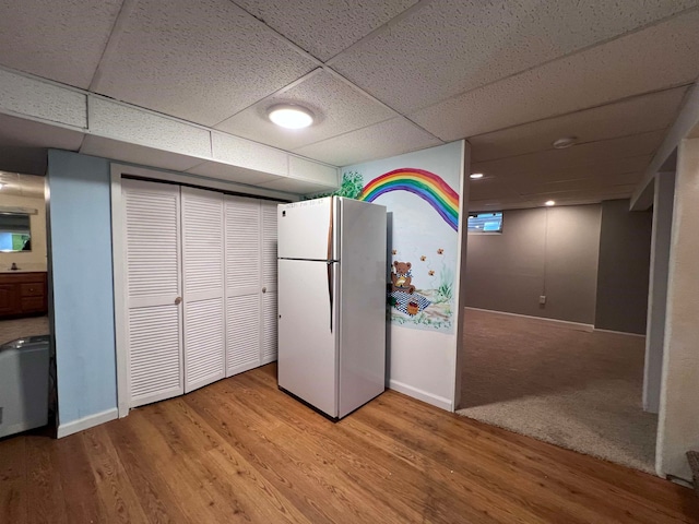 kitchen with a drop ceiling, white refrigerator, and light hardwood / wood-style floors