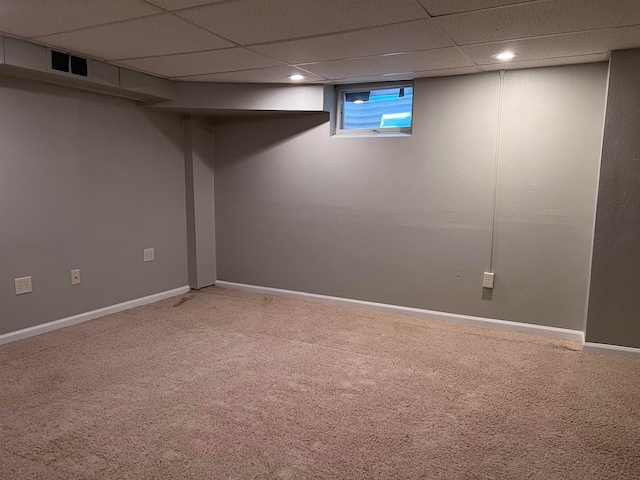 basement with carpet flooring and a paneled ceiling