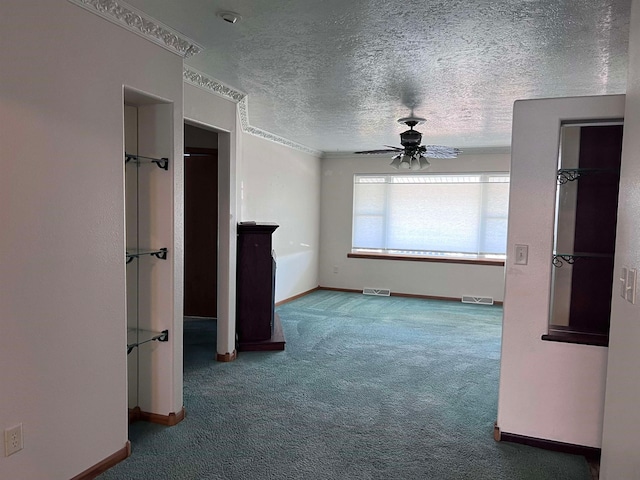 spare room with carpet, ceiling fan, and a textured ceiling