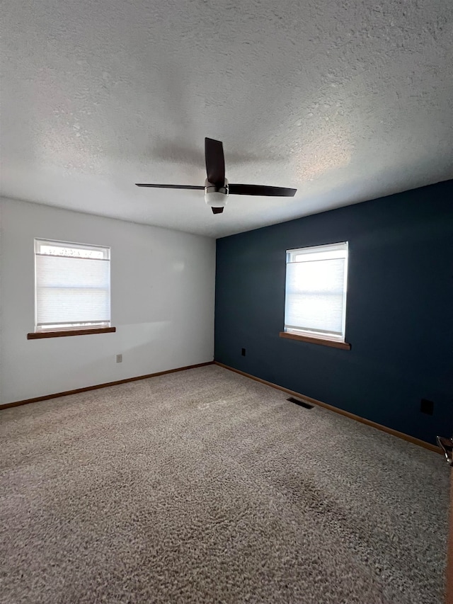 unfurnished room featuring carpet flooring, ceiling fan, and a textured ceiling