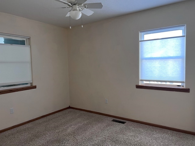 carpeted spare room featuring ceiling fan