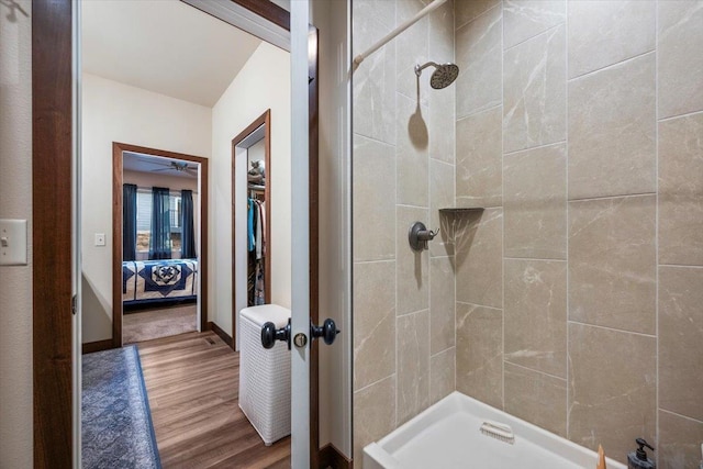 bathroom with hardwood / wood-style floors and a tile shower