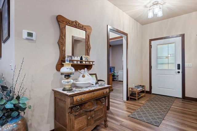 entrance foyer with light hardwood / wood-style floors and a notable chandelier