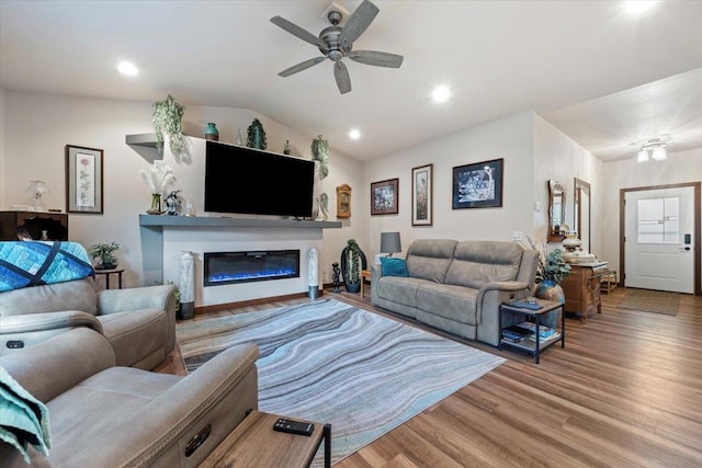 living room featuring hardwood / wood-style flooring, ceiling fan, and vaulted ceiling