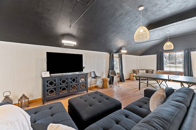 living room with a textured ceiling, wood-type flooring, and lofted ceiling