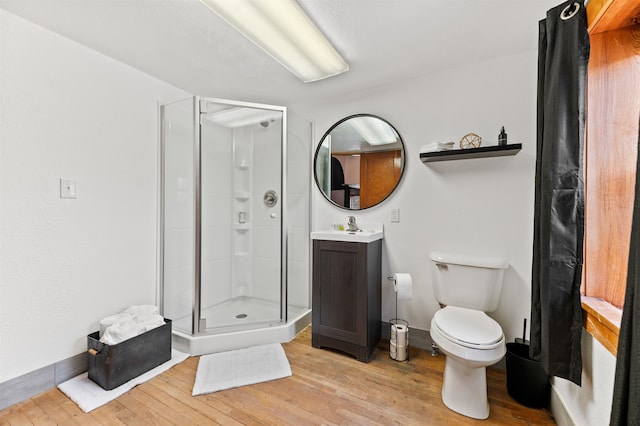 bathroom featuring toilet, an enclosed shower, wood-type flooring, and vanity