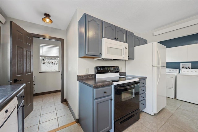 kitchen with gray cabinets, light tile patterned floors, washer and dryer, and white appliances