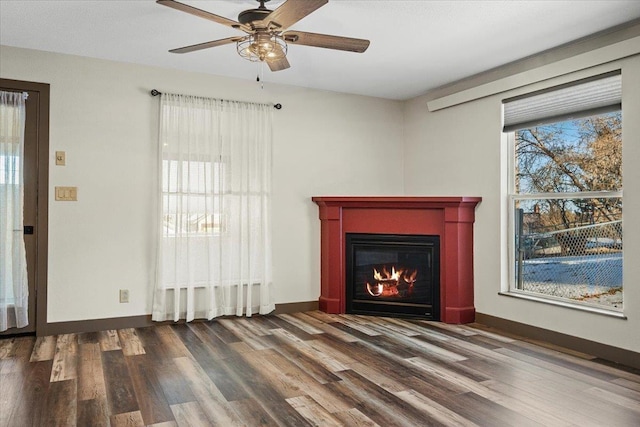 unfurnished living room with dark hardwood / wood-style flooring and ceiling fan