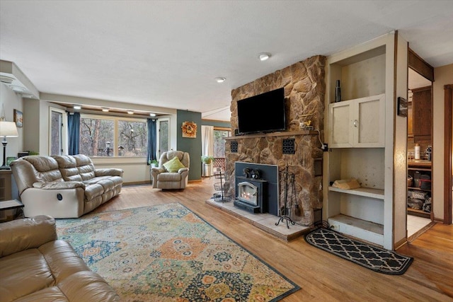 living room with a wood stove and wood-type flooring