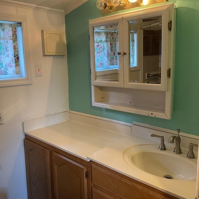 bathroom with a wealth of natural light, vanity, and ornamental molding