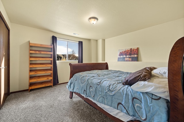 carpeted bedroom with a textured ceiling and a closet