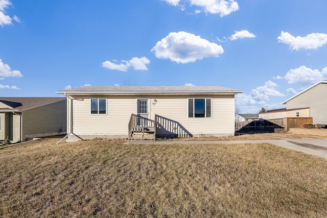 rear view of property featuring a lawn