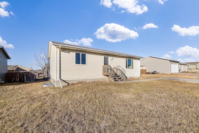 rear view of house featuring a yard and a garage