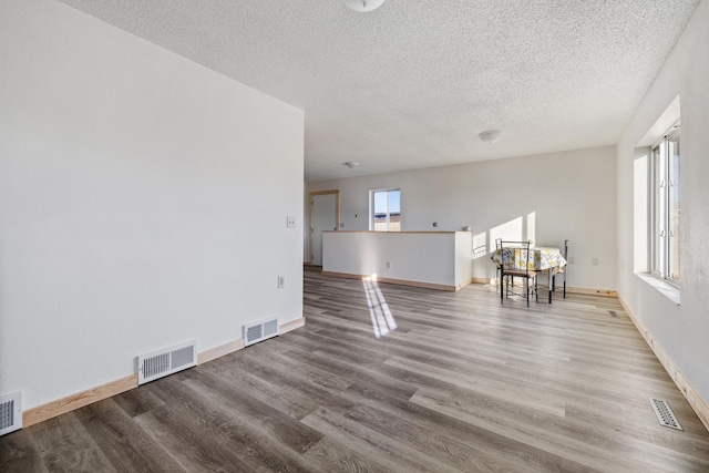 unfurnished living room featuring wood-type flooring and a textured ceiling