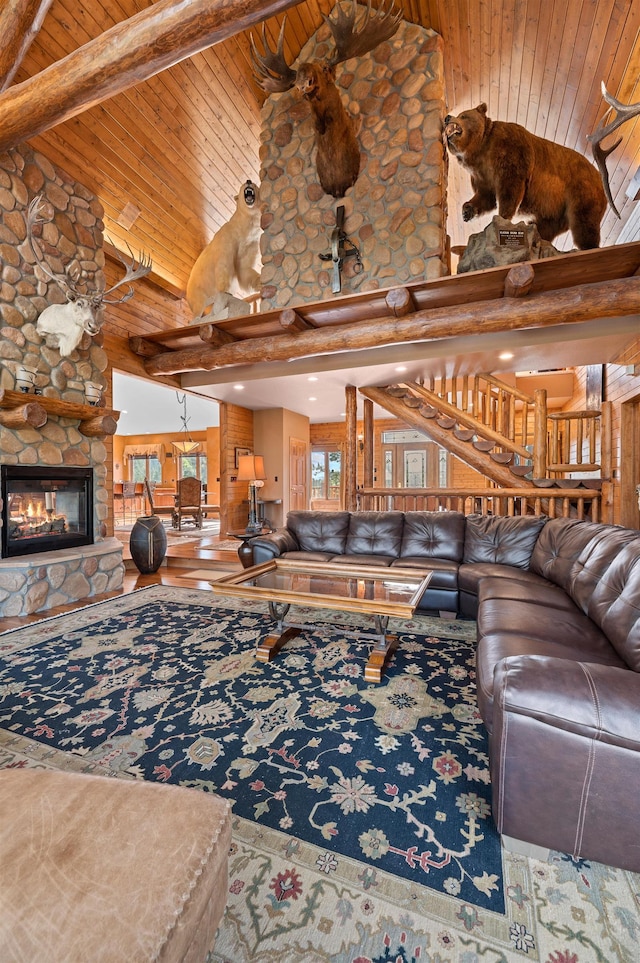 unfurnished living room featuring beamed ceiling, a stone fireplace, wood ceiling, and high vaulted ceiling