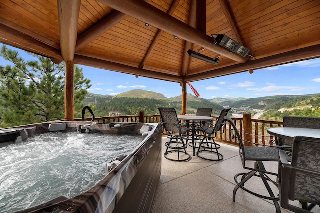 view of patio / terrace featuring a gazebo, a mountain view, and a hot tub