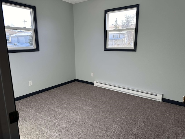 carpeted empty room featuring a baseboard radiator and a wealth of natural light