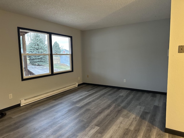 spare room with a textured ceiling, dark hardwood / wood-style floors, and baseboard heating