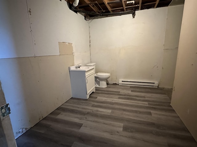 basement featuring sink, dark hardwood / wood-style flooring, and baseboard heating