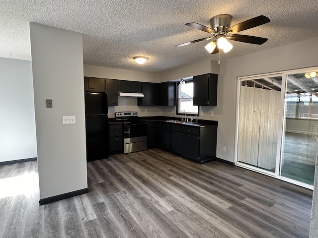 kitchen featuring black refrigerator, stainless steel range with electric cooktop, wood-type flooring, and a textured ceiling