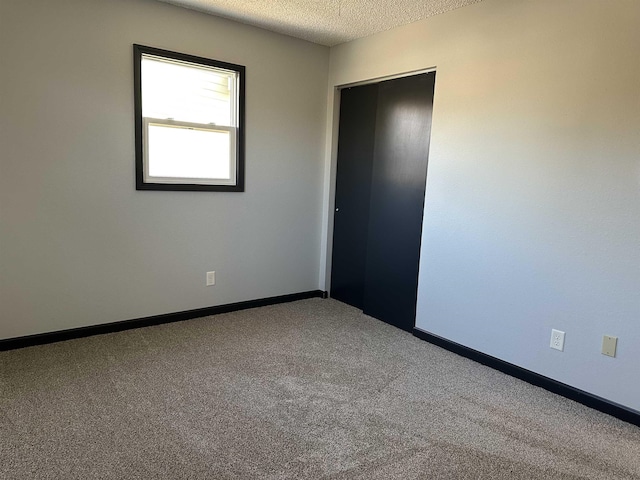 spare room featuring carpet and a textured ceiling